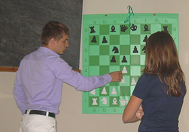  mentre spiega alla scacchiera murale 